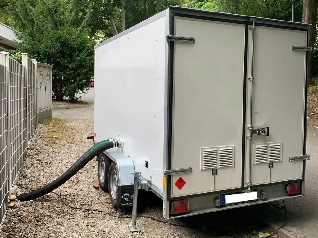 Mobile Heizung im Anhänger, mit Schläuchen an das Heizungssystem im Haus angeschlossen